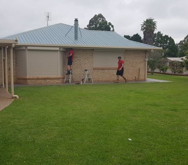 Two Workers Installing Roller Shutters